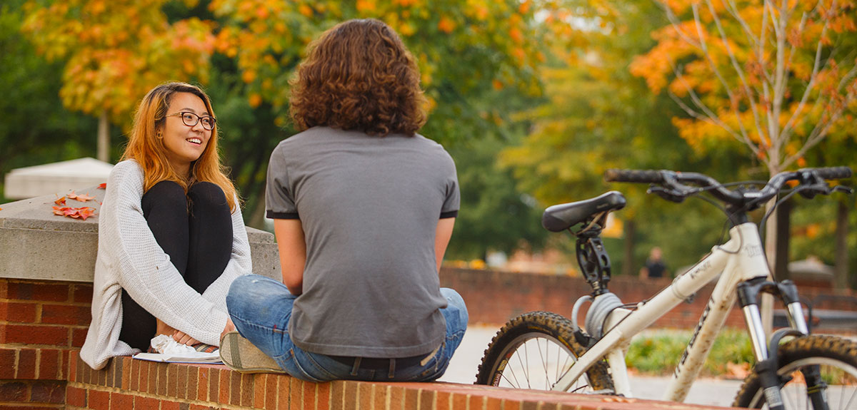 Students chatting by a bicycle
